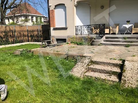 Ancienne terrasse fissurée et envahie par l'herbe