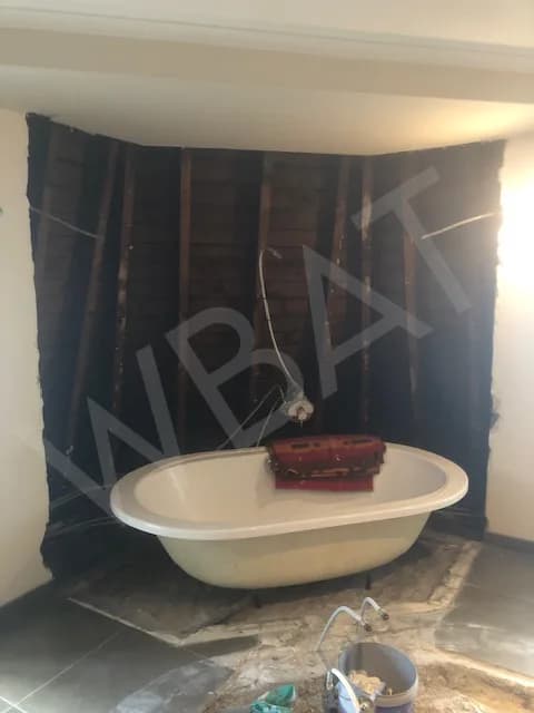 Salle de bain en cours de démolition avec l'ancienne baignoire