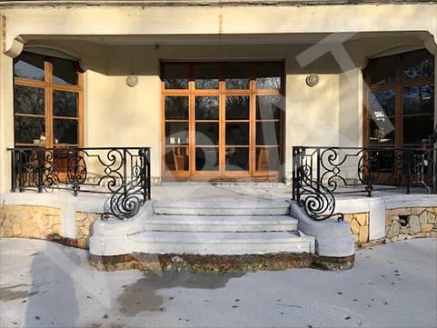Façade et escalier d'entrée avec garde-corps en fer forgé