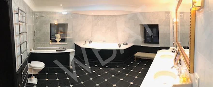 Vue panoramique de la salle de bain rénovée avec meuble vasque noir