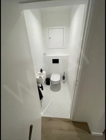 WC rénové avec cuvette suspendue et murs blancs